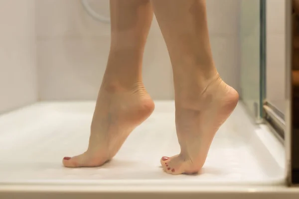 Jong sexy slank vrouw het nemen van een douche en staan op de tegelvloer — Stockfoto