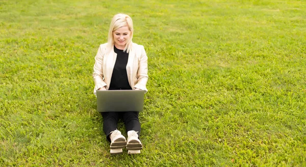 Copywriter mujer que trabaja en el ordenador portátil en el parque, vista sobre el hombro — Foto de Stock