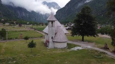 Arnavutluk 'un Theth kentindeki Alp köyü. Geleneksel kilise misafir evleri ve dağlarla çevrili.