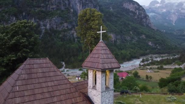 Theth alpesi faluja, Albánia. Hagyományos templom körül vendégházak és hegyek — Stock videók