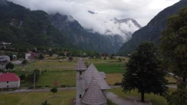 Arnavutluk 'un Theth kentindeki Alp köyü. Geleneksel kilise misafir evleri ve dağlarla çevrili.