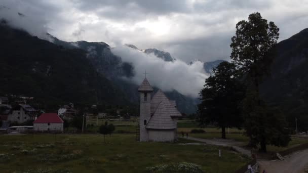 Alpendorp Theth, Albanië. Traditionele kerk omringd door pensions en bergen — Stockvideo