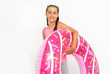 Sevimli küçük kız büyük pembe lastik yüzükle eğleniyor, yaz tatillerini geçiriyor.