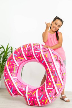 Sevimli küçük kız büyük pembe lastik yüzükle eğleniyor, yaz tatillerini geçiriyor.