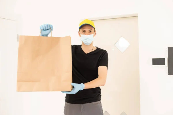 Homem de entrega em luvas protetoras e uma máscara — Fotografia de Stock