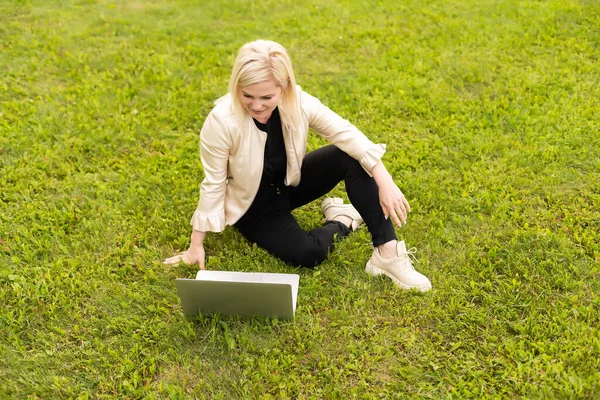 Молодая женщина с ноутбуком в парке — стоковое фото