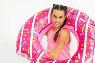 Sevimli küçük kız büyük pembe lastik yüzükle eğleniyor, yaz tatillerini geçiriyor.