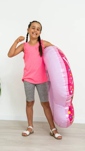 Carino felice bambina divertirsi con grande anello di gomma rosa, trascorrere le vacanze estive — Foto Stock