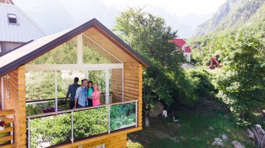 Dağ evinin terasında neşeli bir aile.