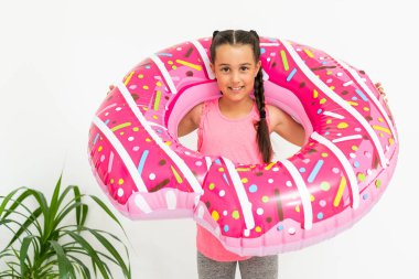 Sevimli küçük kız büyük pembe lastik yüzükle eğleniyor, yaz tatillerini geçiriyor.