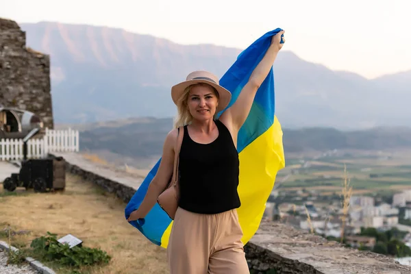 Młoda szczęśliwa kobieta z flagą Ukrainy i plecakiem. Dzień Niepodległości Ukraina. — Zdjęcie stockowe