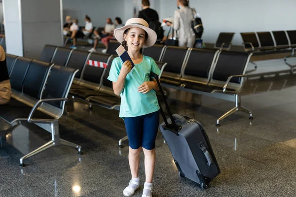 Hermosa niña con pasaporte y tarjeta de embarque en el aeropuerto — Foto de Stock