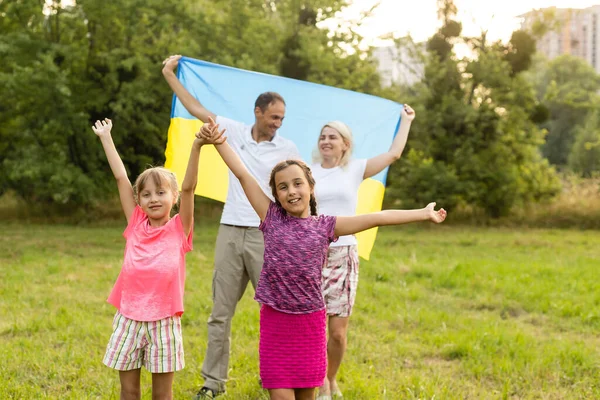 Счастливая семья с флагом Украины в поле. — стоковое фото