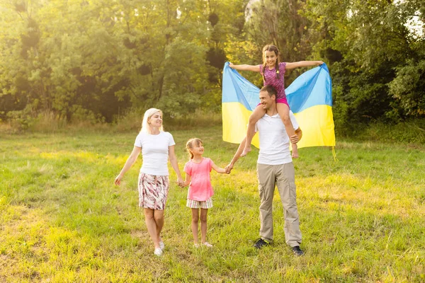 Szczęśliwa rodzina s z flagą Ukrainy w polu. — Zdjęcie stockowe