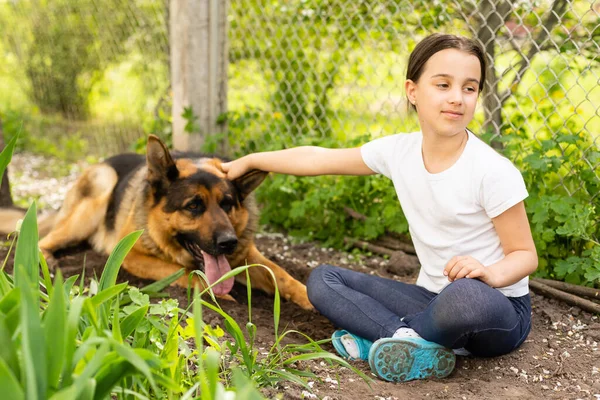 Menina alegre com um cão pastor alemão — Fotografia de Stock