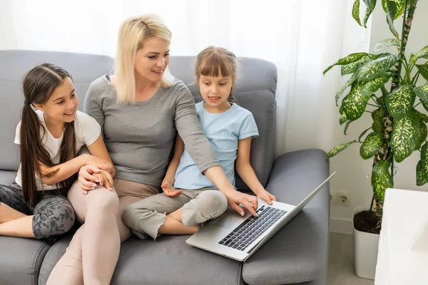 A trabalhar em casa com um miúdo. Mãe feliz e filha compras on-line, usando laptop juntos. Mulher abraçando criança. Local de trabalho freelancer na mesa da cozinha. Negócios femininos, comunicação virtual. — Fotografia de Stock