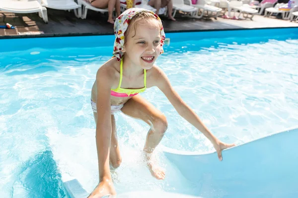 Glückliches Kind, das im Schwimmbad spielt. Sommerferienkonzept — Stockfoto