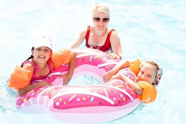 Famille heureuse dans la piscine, s'amuser dans l'eau, mère avec enfants profitant d'un parc aquatique, station balnéaire, vacances d'été, concept de vacances — Photo