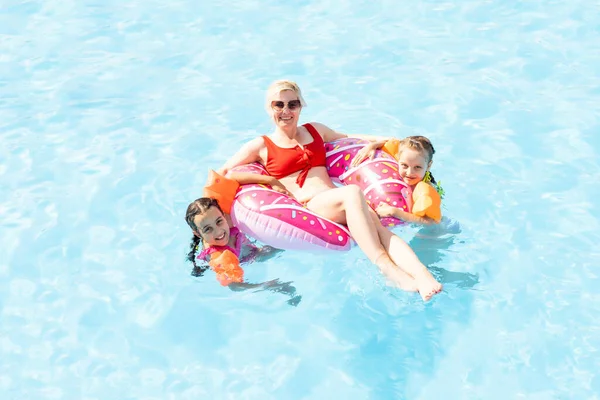 Bambini che giocano in piscina. Due bambine che si divertono in piscina. Vacanze estive e concetto di vacanza — Foto Stock
