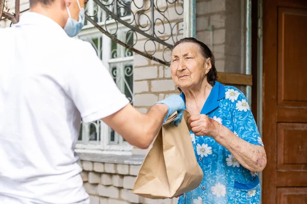 Voedsel levering man voor een oudere vrouw — Stockfoto