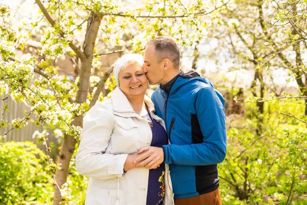 Uomo che abbraccia sua madre in giardino — Foto Stock