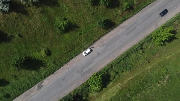 Luchtfoto van landelijke wegen. Zicht op rijstvelden langs de weg. De weg langs cultuurgebied, platteland. — Stockvideo