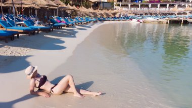 Arnavutluk 'un güzel Ksamil plajında güneşlik şemsiyeler ve şezlonglar.