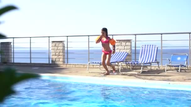 Hermosa niña saltando en la piscina contra el mar — Vídeos de Stock