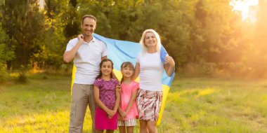 Tarlada Ukrayna bayrağı taşıyan mutlu aile.