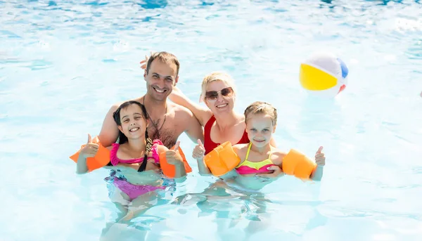 Hermosa familia divirtiéndose en una piscina — Foto de Stock
