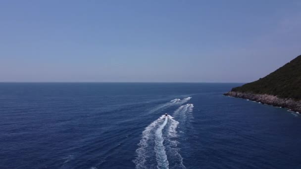 Drone uitzicht op een boot de blauwe heldere wateren. Bovenaanzicht van een witte boot die naar de blauwe zee vaart. Grote speedboot in beweging met hoge snelheid. Reizen - beeld — Stockvideo