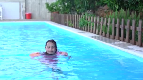 Söt liten flicka simmar i utomhuspool och har en rolig — Stockvideo