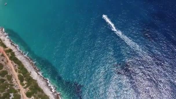 Drone uitzicht op een boot de blauwe heldere wateren. Bovenaanzicht van een witte boot die naar de blauwe zee vaart. Grote speedboot in beweging met hoge snelheid. Reizen - beeld — Stockvideo