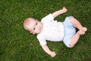 Çimlerde güzel bir bebeğin yaz portresi