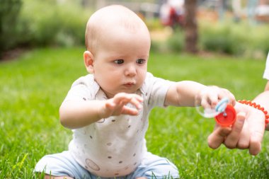 Dışarıdaki yeşil çimlerde küçük bir bebek