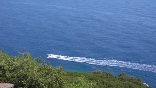 Drone vista de un barco las aguas cristalinas azules. Vista superior de un barco blanco navegando hacia el mar azul. Barco de gran velocidad moviéndose a alta velocidad. Viajes - imagen — Vídeos de Stock