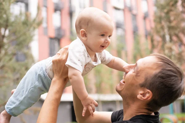 年轻英俊的父亲抱着可爱可爱的新生男婴的画像。生活方式。真正的人父亲和父母的概念。父亲节快乐. — 图库照片