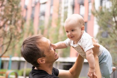 Babası ve oğlu yaz parkında yürüyor.