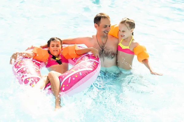 Familia feliz divirtiéndose en las vacaciones de verano, jugando en la piscina. Concepto de estilo de vida saludable activo — Foto de Stock