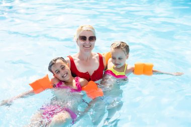 Küçük bir kıza yüzmeyi öğreten bir kadın. Metin için yer.