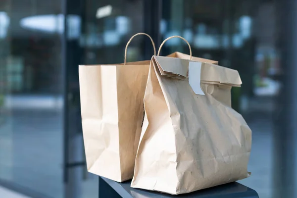 Bolsa de papel cerca de la puerta de la casa. Concepto de entrega segura. Entrega de comida a domicilio sin contacto. Medidas cautelares. — Foto de Stock