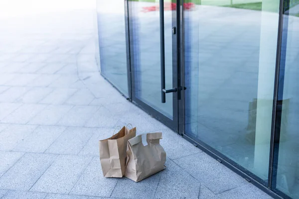 Saco de papel perto da porta da casa. Conceito de entrega segura. Entrega de comida caseira sem contacto. Medidas cautelares. — Fotografia de Stock