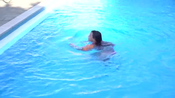 Pretty little girl swimming in outdoor pool and have a fun — Stock Video