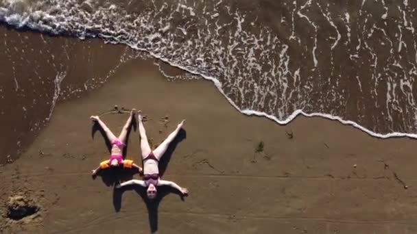 Moeder en dochter spelen op het zandstrand. Gelukkige familie aan de zandkust — Stockvideo