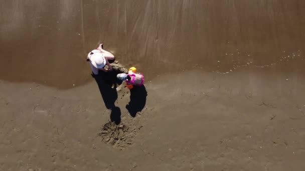 Anne ve kızı kumsalda oynuyorlar. — Stok video