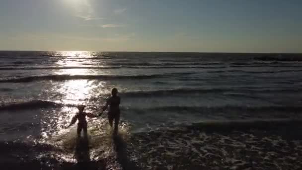 Moeder en dochter spelen op het zandstrand — Stockvideo