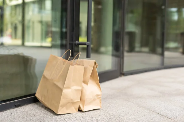 Bolsa de papel cerca de la puerta de la casa. Concepto de entrega segura. Entrega de comida a domicilio sin contacto. Medidas cautelares. —  Fotos de Stock