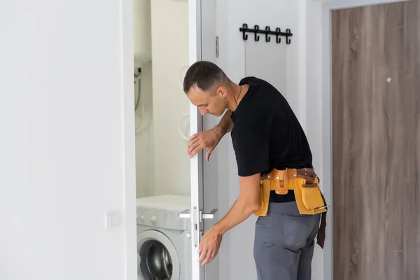 Male worker handyman carpenter installation into wood door — Stock Photo, Image