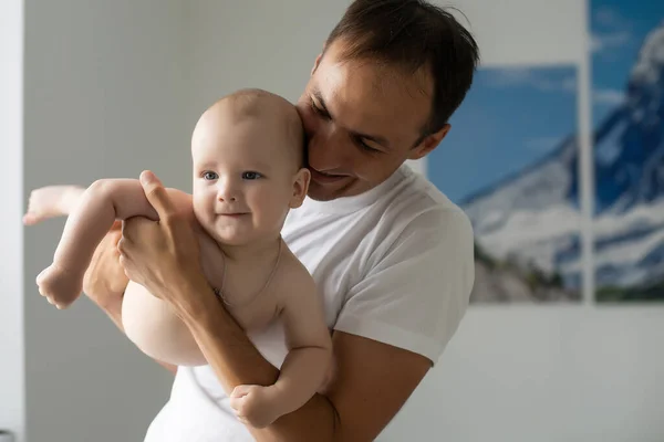 Boldog fiatalember kezében egy mosolygó 6 hónapos baba — Stock Fotó