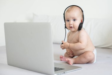 Beyaz arka planda dizüstü bilgisayarı olan bebek.
